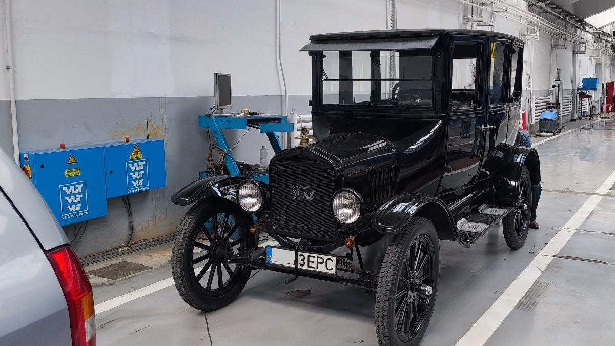 O mașină clasică, de epocă, de culoare neagră - Ford T, într-o hală a Registrului Auto Român.