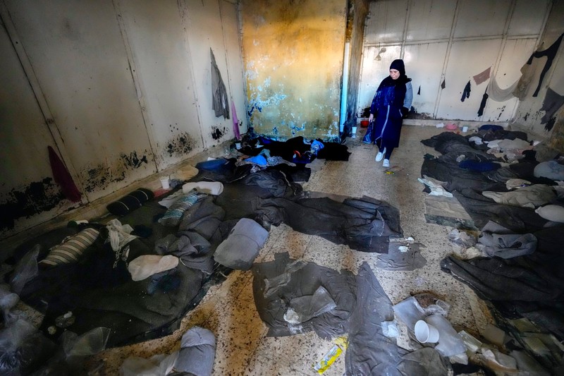 A woman looks at blankets and other clothes lying on the floor in a room of the infamous Saydnaya military prison, just north of Damascus, Syria, Monday, Dec. 9, 2024. Crowds are gathering to enter the prison, known as the "human slaughterhouse," after thousands of inmates were released following the rebels' overthrow of Bashar al-Assad's regime on Sunday.,Image: 944760011, License: Rights-managed, Restrictions: This content is intended for editorial use only. For other uses, additional clearances may be required., Model Release: no, Pictured: Bashar Assad