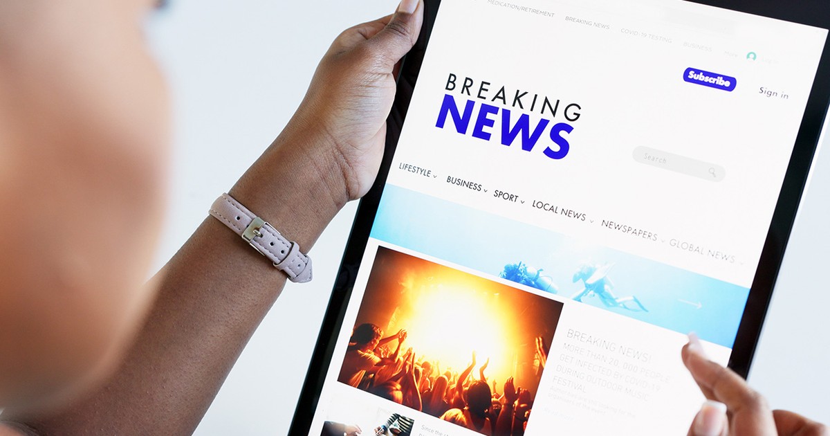O femeie care privește un ecran de tabletă pe care scrie Breaking News,