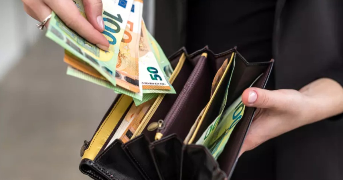 O femeie care pune bancnote euro în portofel.
