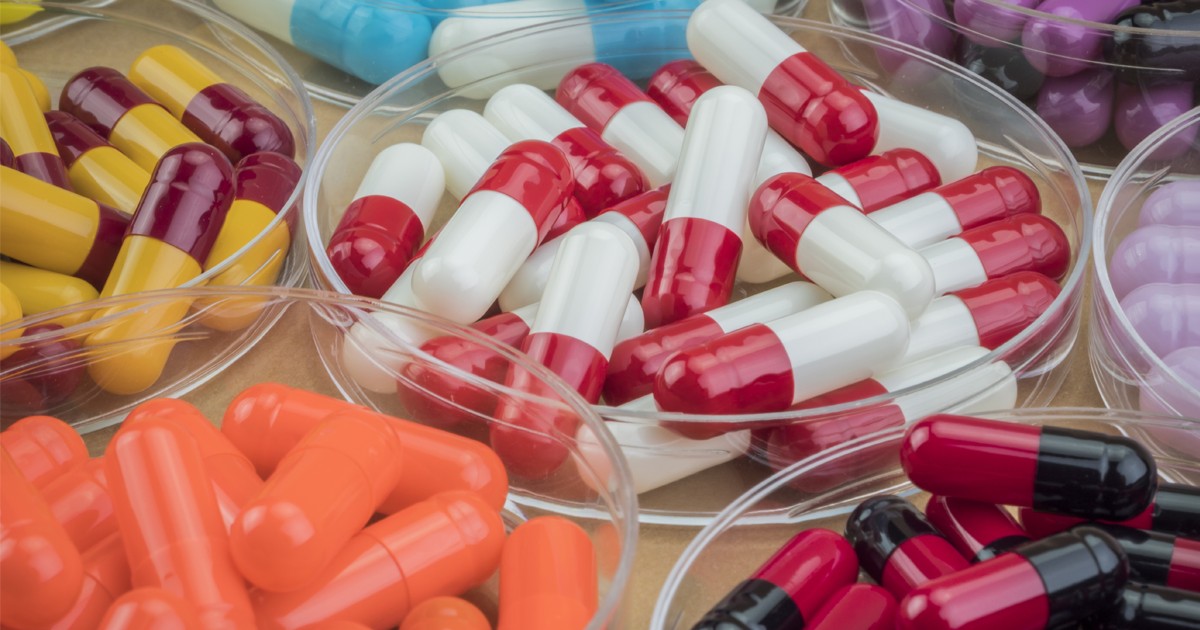 Pe o masă sunt mai multe boluri cu medicamente. Un milion de oameni mor anual din cauza medicamentelor contrafăcute. Foto Envato
