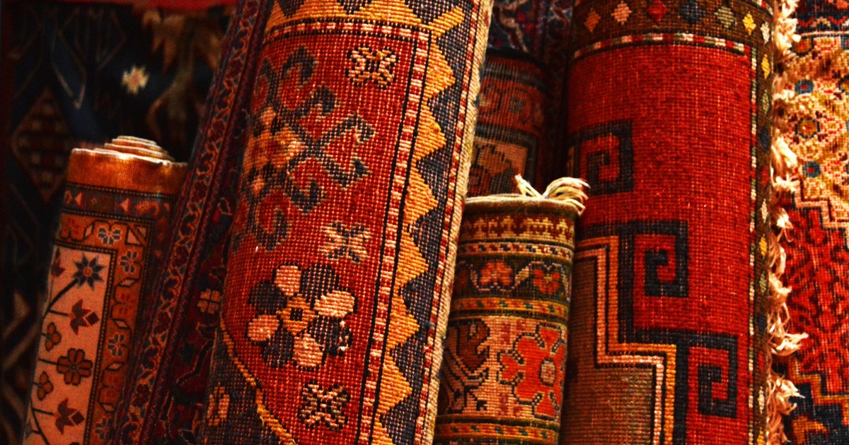 Covor rosu cu model tribal in portocaliu si maro si franjuri albe