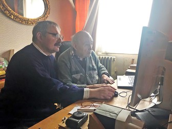 Mircea Pauca, stânga, se uită împreună cu tatăl sau la fotografii din arhiva familiei
