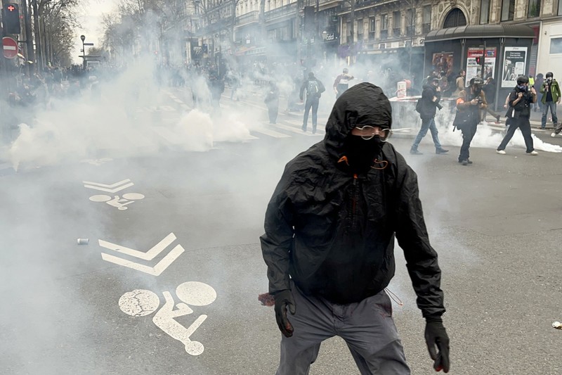 8397379 23.03.2023 A demonstrator walks amid fuming tear gas pellets during a protest against the government that pushed a pensions reform through parliament without a vote, using the article 49.3 of the constitution, in Paris, France. Protests continue across the country due to the French government's plan to raise retirement age from 62 to 64 by 2030. Evgeny Poloyko / Sputnik