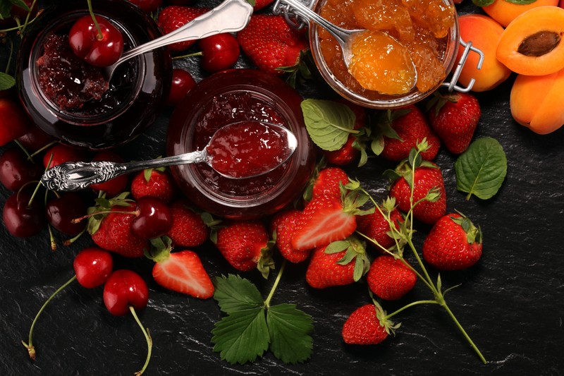 assortment of jams, seasonal berries, apricot, mint and fruits. marmalade or confiture