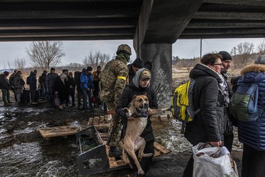 Oamenii din Irpin trec peste un pod distrus pentru a părăsi orașul | Foto: EPA