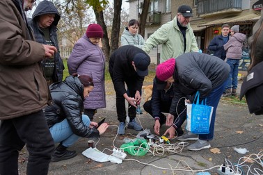 Oamenii își încarcă telefoanele în piața centrală din Herson, pe 17 noiembrie. | Foto: Profimedia