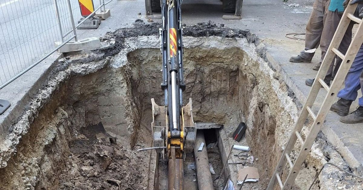Mai mulți muncitori lucrează la schimbarea unor țevi, după ce a apărut o avarie la conductele de apă caldă