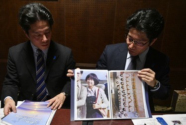Takuya și Tetsuya Yokota arată presei o fotografie cu sora lor, Megumi FOTO: EPA