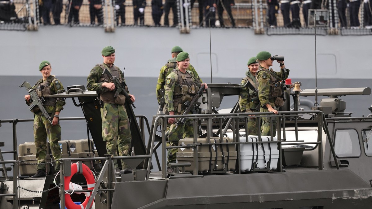 Soldați suedezi stau la bordul unei ambarcațiuni rapide de asalt CB90 a Marinei Suedeze, în fața fregatei franceze „Amiral Ronarc’h”, la Stockholm, Suedia, pe 31 august 2026, înaintea unei întâlniri bilaterale între partea franceză