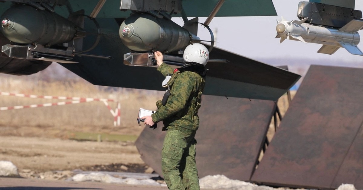 Un militar rus verifică face ultimele verificări la un avion militar Su-34, încărcat cu bombe FAB-500. Imagine realizată de Ministerul rus al Apărării / Profimedia