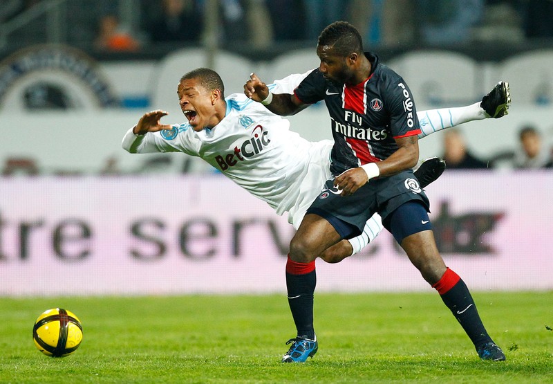 Siaka Tiene (R) of Paris Saint Germain challenges Stephane Loic Remy (L) of Olympique Marseille during their soccer League One match in the Stade Velodrome, Marseille, France, 20 March 2011. EPA/GUILLAUME HORCAJUELO