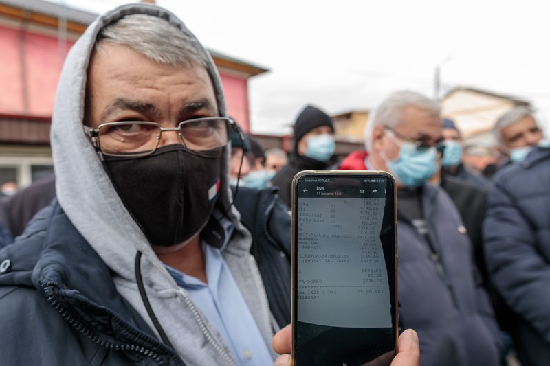Un șofer de autobuz arată fluturașul de salariu - 4.500 de lei. Foto: Vlad Chirea