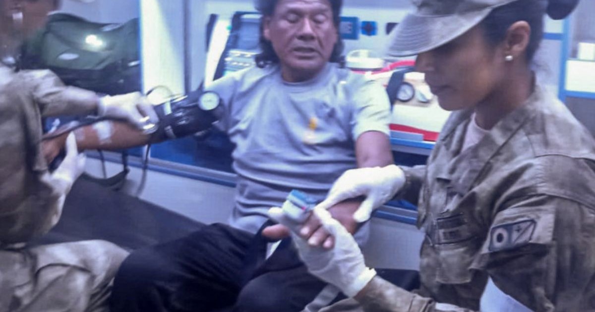 Bărbat din Peru savat se află în ambulanță unde i se fac investigații de rutina de un medic si un medic militar îi monitorizează saturația.