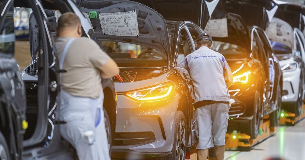 Muncitori care asamblează mașini la o fabrică Volkswagen din Germania