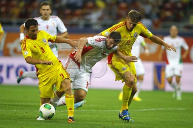 epa03854749 Daniel Bode (C) of Hungary vies for the ball with Razvan Rat (L) and Dorin Goian (R ) of Romania during the FIFA 2014 World Cup qualifier soccer match between Romania and Hungary at National Arena stadium in Bucharest, Romania, 06 September 2013. EPA/ROBERT GHEMENT