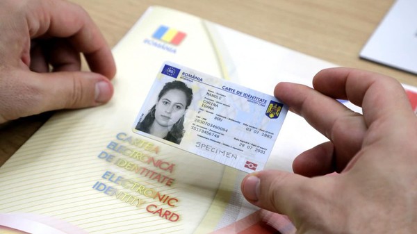 Un bărbat ține în mână o carte electronică de identitate