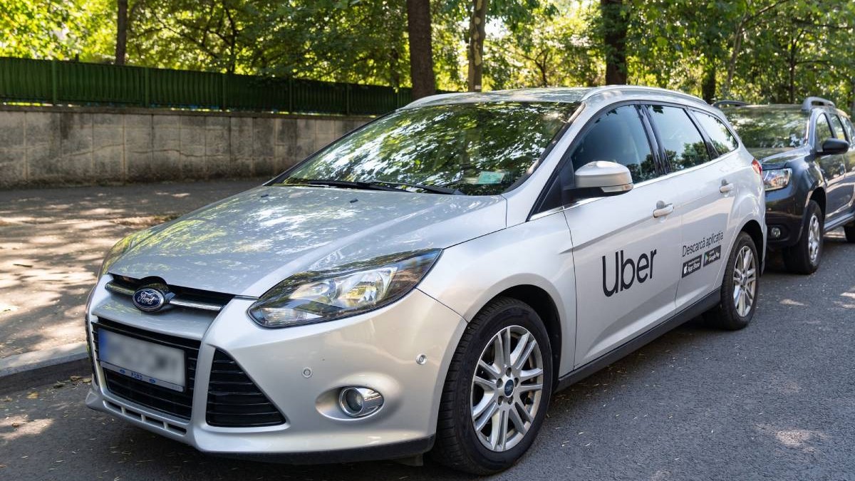 masina ford gri cu autocoland scris uber pe usa din stanga fata
