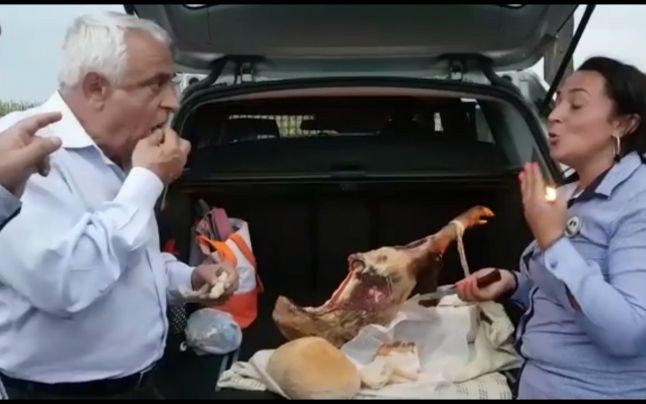 Petre Daea mănâncă jambon din portbagajul unei maşini. Imaginile au fost f[cute publice