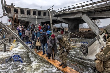 Oamenii din Irpin trec peste un pod distrus pentru a părăsi orașul | Foto: EPA