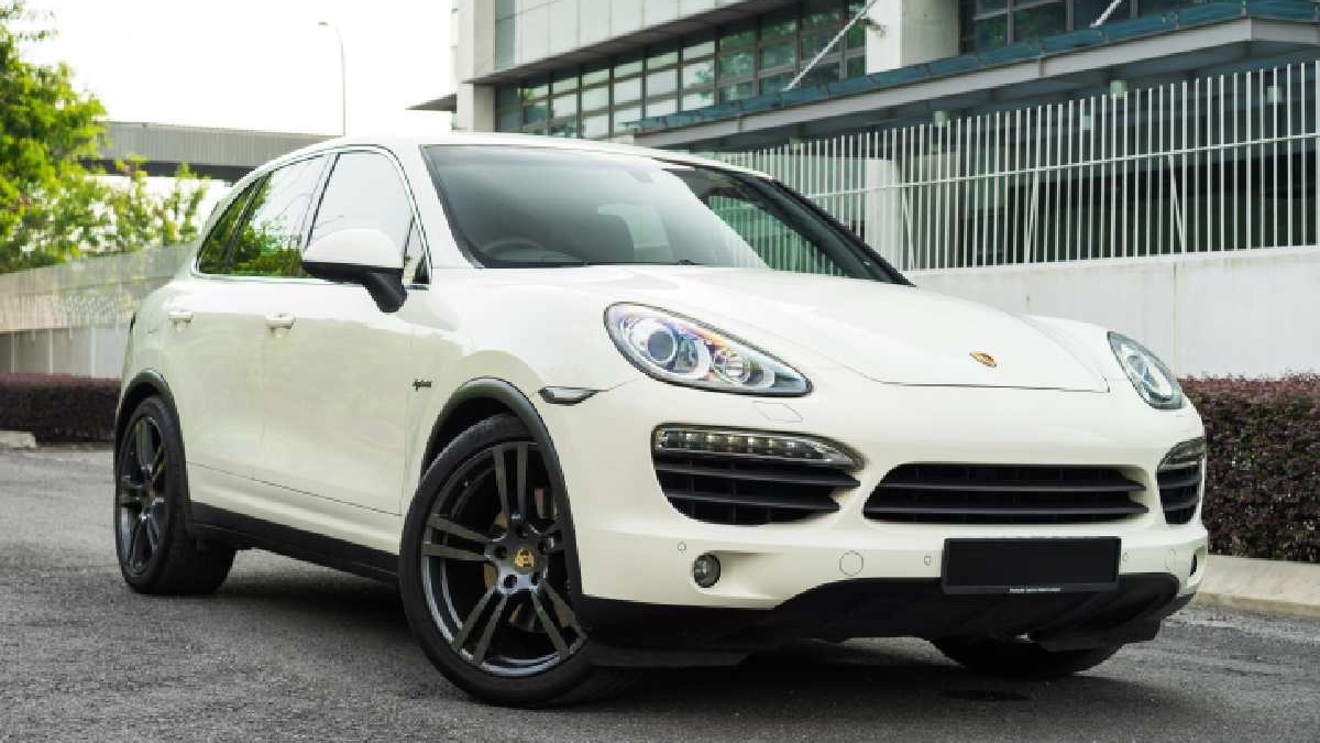 Un autoturism Porsche Cayenne parcat lângă o clădire