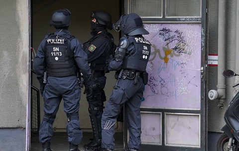 Polițiști înarmați care stau în fața unei clădiri
