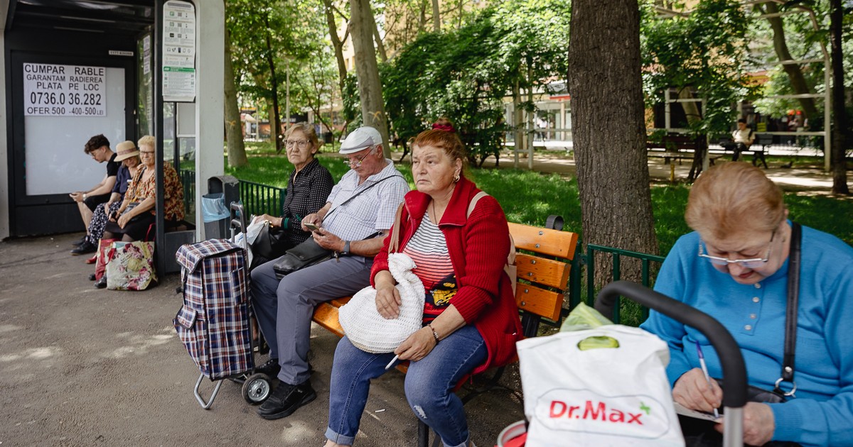 Pensionari asteapta autobuzul intr-o statie