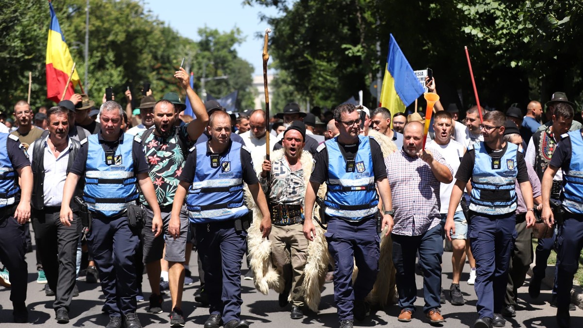 Mai multi fermieri incadrati de jandarmi protesteaza pe o strada din Bucuresti