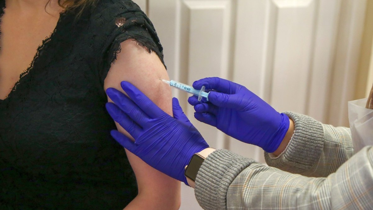 Un asistent medical administrează vaccinul Moderna anti COVID-19 la un centru de vaccinare. Foto: Hepta