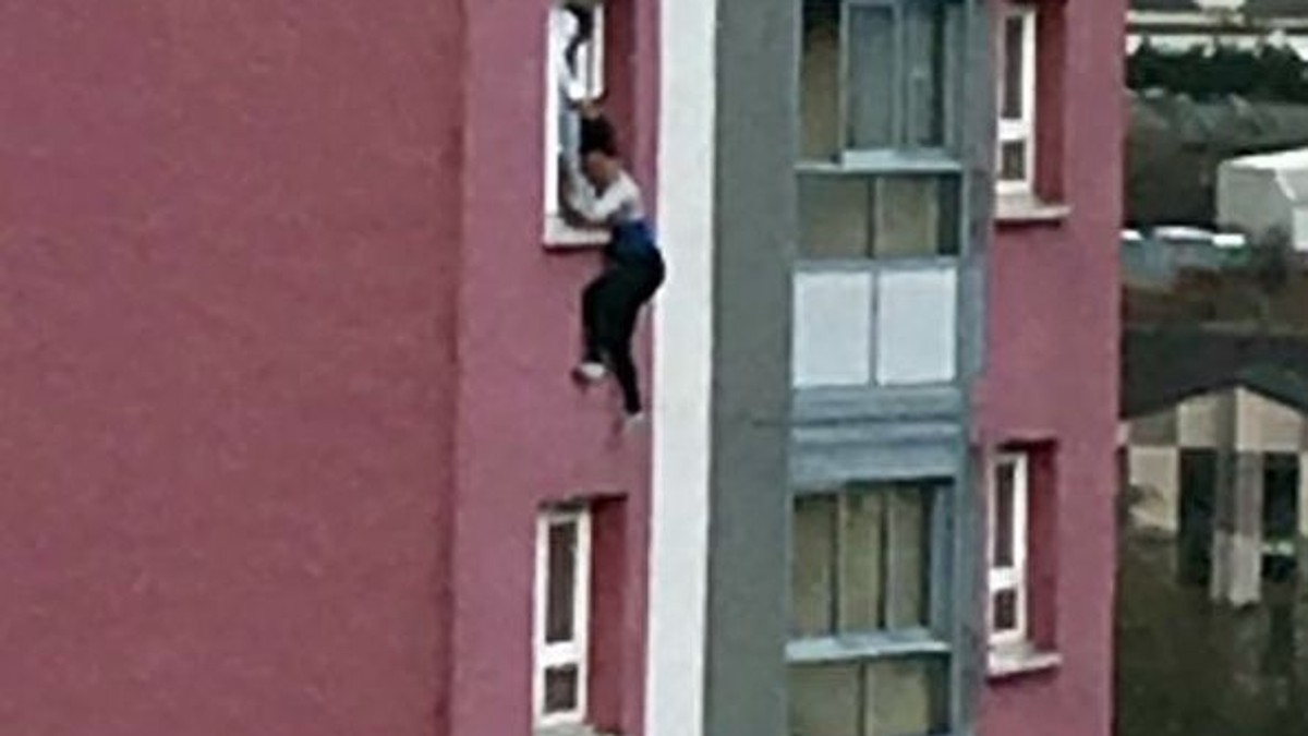 Moment dramatic surprins de un trecător: O femeie ținută de păr, pe geam, înainte să cadă de la etajul 11