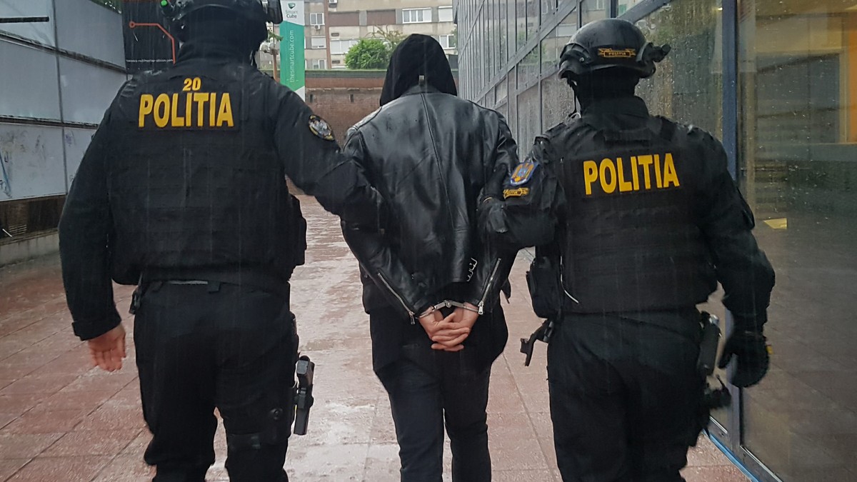 Polițiști mascați, reținând un bărbat. Fotografie cu caracter ilustrativ