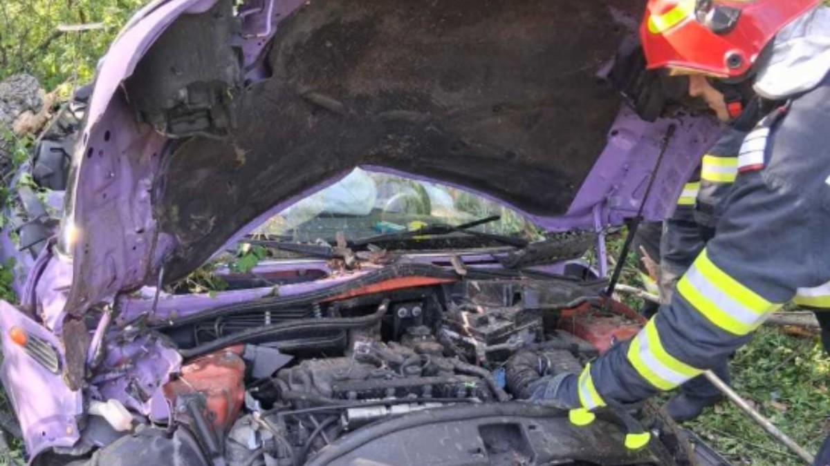 Un pompier lângă o mașină avariată în urma unui accident