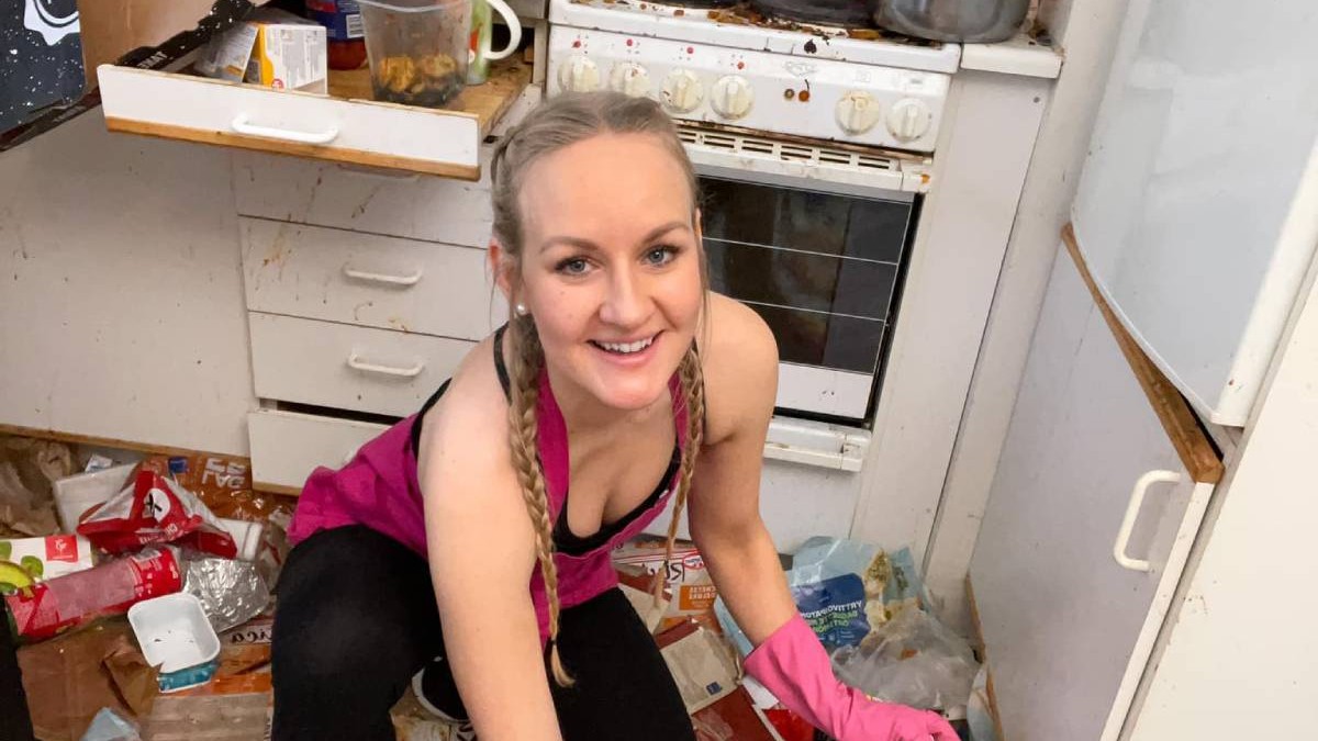 Auri Kenanen, regina curățeniei, o femeie finlandeza tânără, blondă, cu părul împletit în două codițe. Poartă un maiou roz și mănuși de curățenie roz și stă ghemuită într-o bucătărie foarte murdară. Zâmbește în timp ce ridică gunoaie de pe podea. În jurul ei se văd ambalaje aruncate, resturi alimentare, oale și tigăi murdare pe aragaz, precum și sertare și dulapuri deschise, pline de pete și mizerie.
