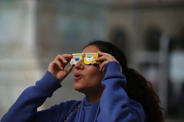 Bucureștenii privesc eclipsa din Piața Universității. | Foto: Dumitru Angelescu / Libertatea