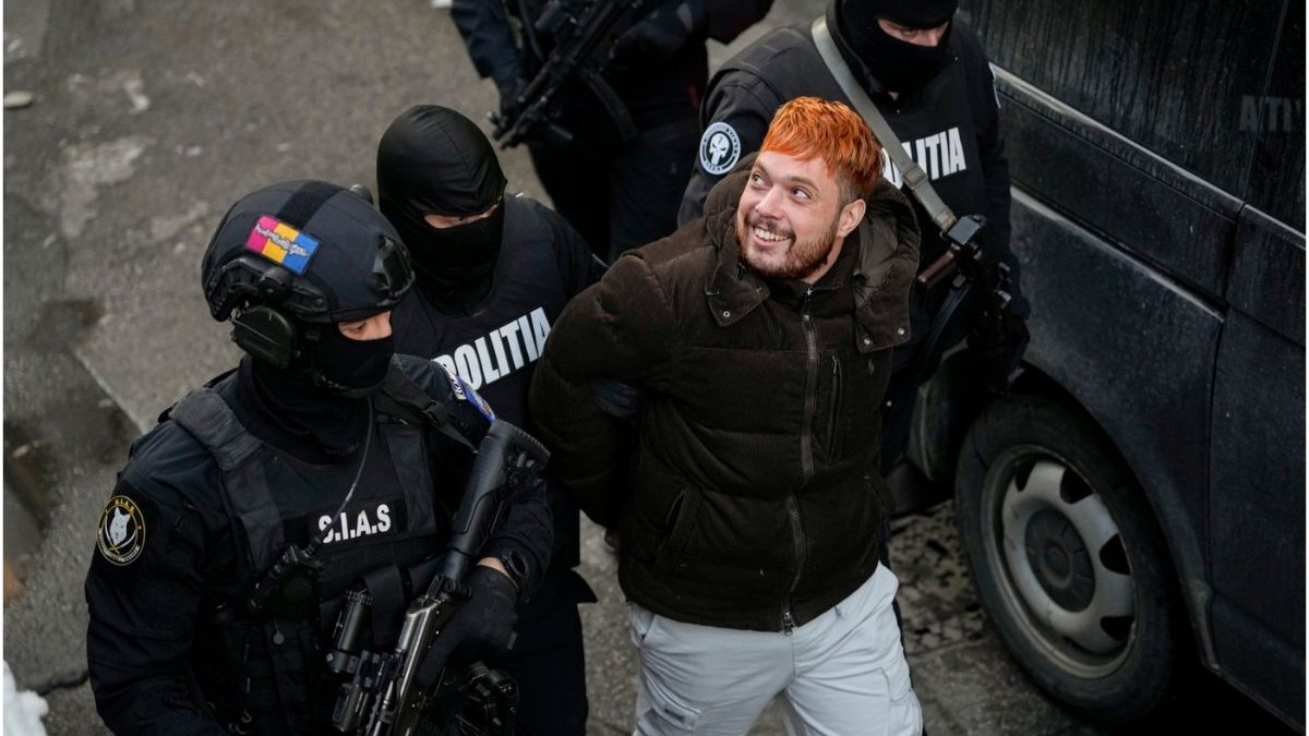 Ofițerii de poliție îl escortează pe Mohamed Amra, 23 februarie 2025, după arestarea sa cu o zi înainte.