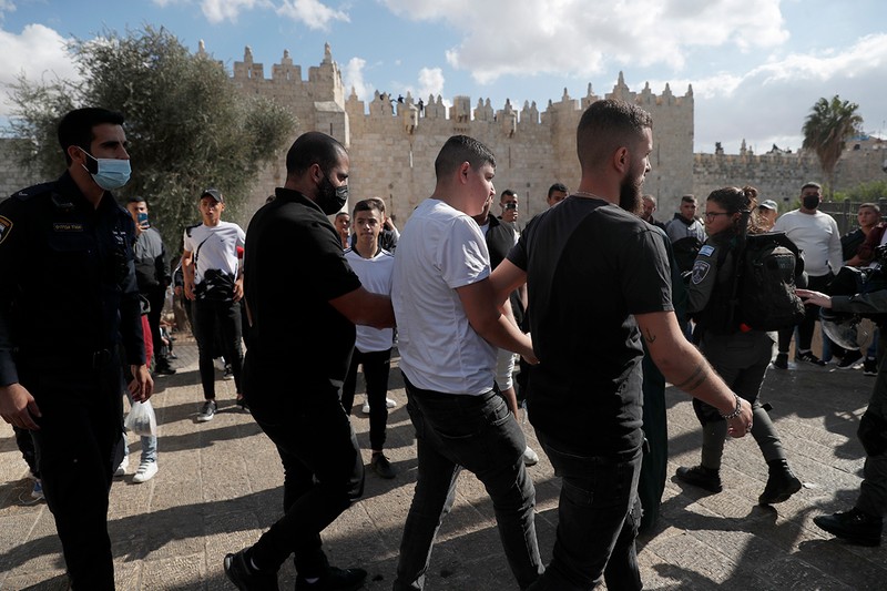 Poliția israeliană reține un tânăr palestinian în timpul ciocnirilor dintre palestinieni și poliția israeliană, după un miting de cercetași la poarta Damasc a orașului vechi al Ierusalimului pentru a marca sărbătorile de naștere a profetului Mahomed, 19 octombrie 2021 | Foto: EPA