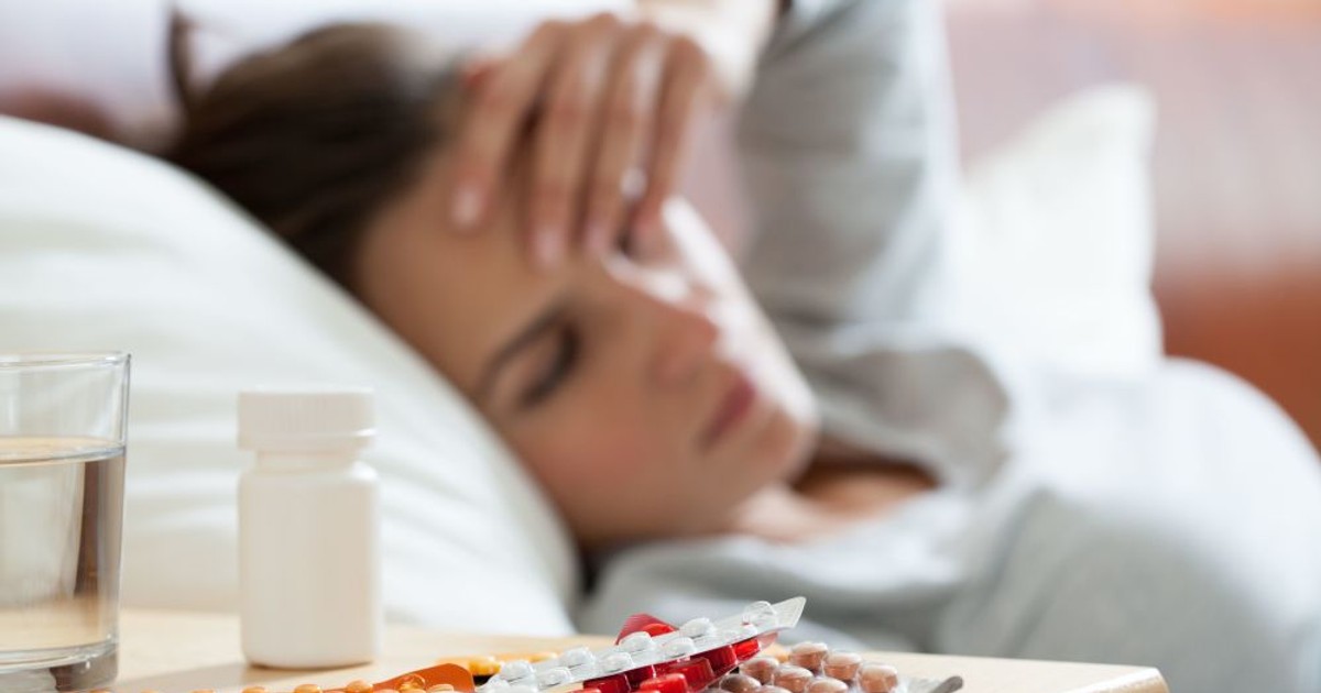 27 de decese, din cauza gripei. O femeie răcită, care își pune mâna pe frunte. Alături, pe un dulăpior sunt multe medicamente