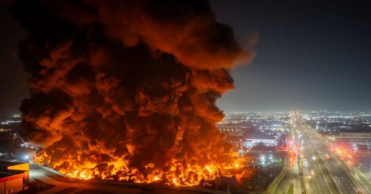 Flăcări și un fum gros și negru se ridică deasupra unei fabrici chimice din Quilicura, Santiago de Chile, la data de 4 august 2026