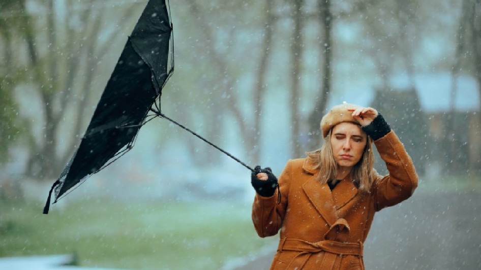 Femeie cu o umbrelă întoarsă de vânt. Persoană nefericită care suferă din cauza vremii furtunoase