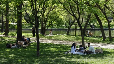 Oameni pe pături în parcul Cișmigiu