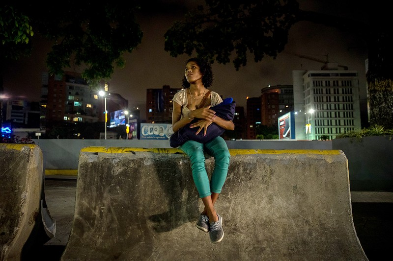 Liliana, 17 ani, o ține în brațe pe fiica ei în varstă de 29 de zile, Angel, pe o stradă din cartierul Las Mercedes din Caracas, Venezuela, 12 decembrie 2018. Liliana, care trăiește pe stradă, suferă de sifilis, iar fiul ei a moștenit boala cu transmitere sexuală. Foto: EPA-EFE/MIGUEL GUTIERREZ