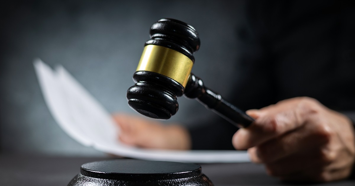 Judecător cu un document pe hârtie care pronunță sentința într-o instanță de judecată