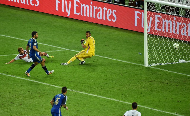 epa04314803 Mario Goetze (back L) of Germany scores the winning goal against Argentinian goalkeeper Sergio Romero (C) of Argentina during the FIFA World Cup 2014 final between Germany and Argentina at the Estadio do Maracana in Rio de Janeiro, Brazil, 13 July 2014. Germany won 1-0 after extra time. (RESTRICTIONS APPLY: Editorial Use Only, not used in association with any commercial entity - Images must not be used in any form of alert service or push service of any kind including via mobile alert services, downloads to mobile devices or MMS messaging - Images must appear as still images and must not emulate match action video footage - No alteration is made to, and no text or image is superimposed over, any published image which: (a) intentionally obscures or removes a sponsor identification image; or (b) adds or overlays the commercial identification of any third party which is not officially associated with the FIFA World Cup) EPA/THOMAS EISENHUTH EDITORIAL USE ONLY