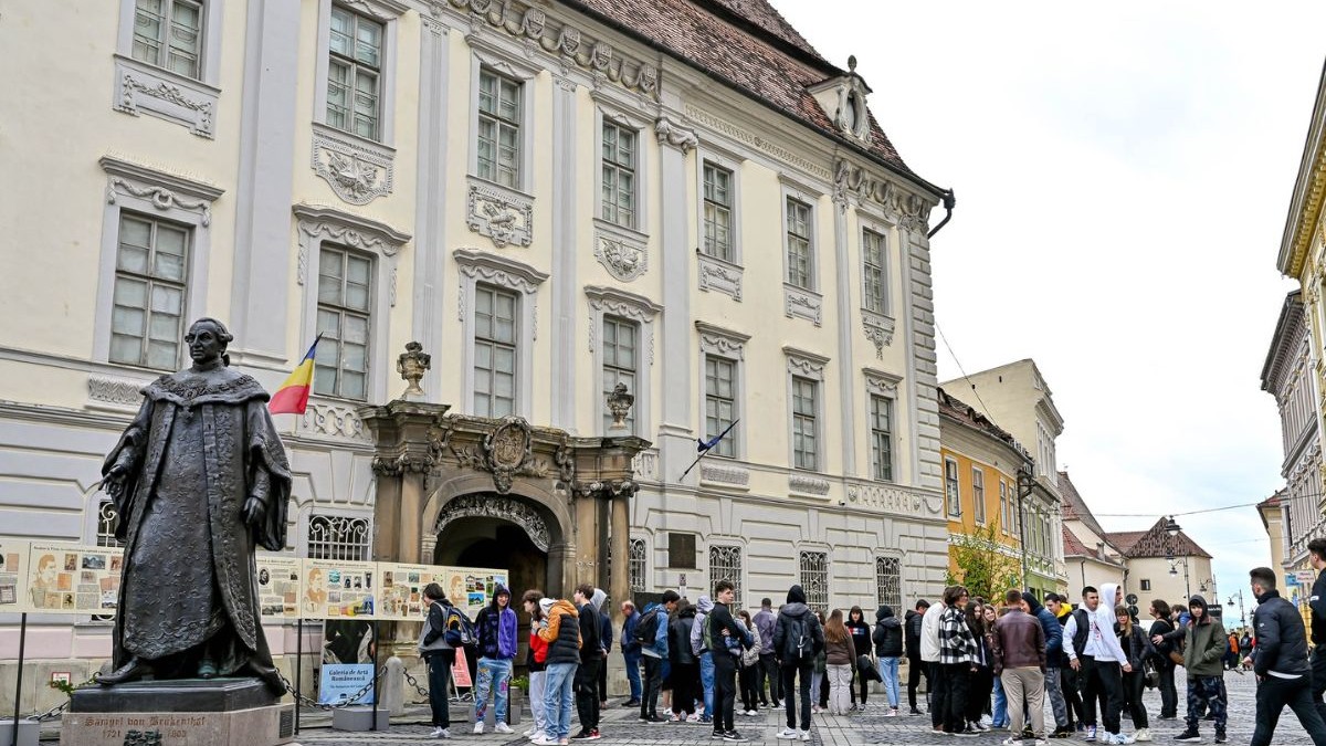 fațada muzeului național Brukenthal din Sibiu, împrjmuită de oameni
