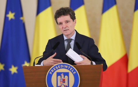 Nicușor Dan, susținând o declarație de presă, având în spate steagurile României și ale Uniunii Europene.
