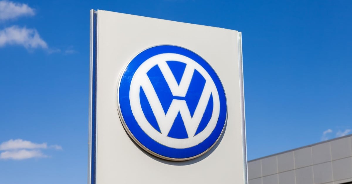 Logo-ul Volkswagen pe un panou. În fundal, cerul este senin.