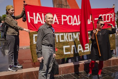 Alexandru se fotografiază după o așteptare greoaie în fața drapelului URSS