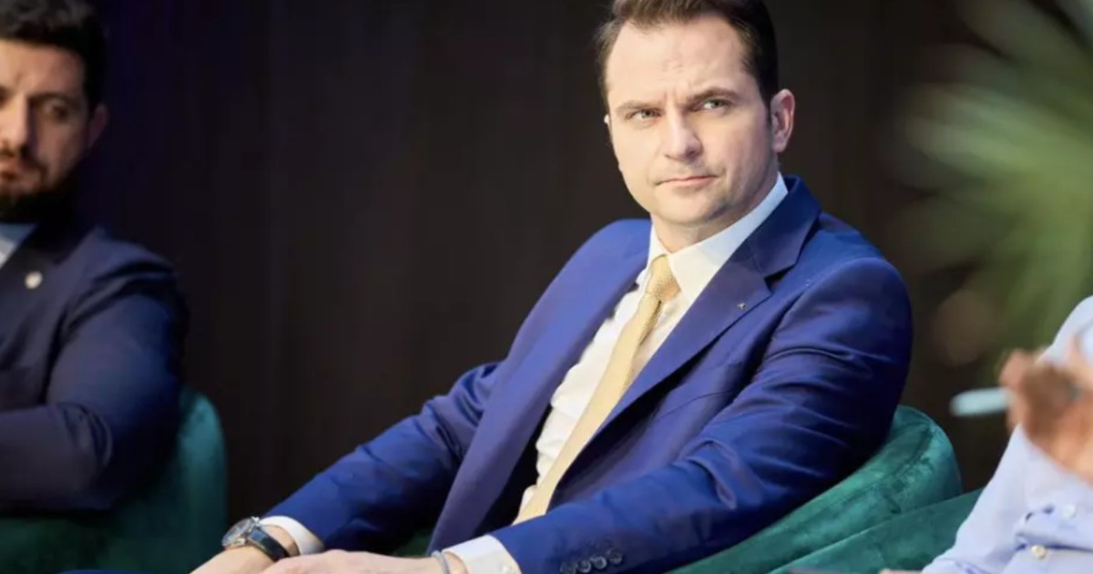Sebastian Burduja, pe un scaun, la o conferință