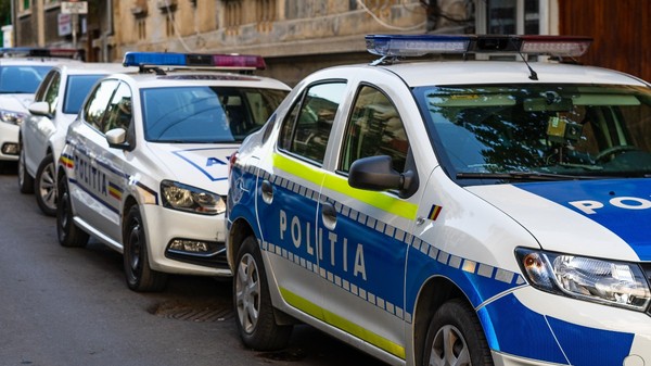 Mai multe mașini de poliție parcate pe marginea drumului