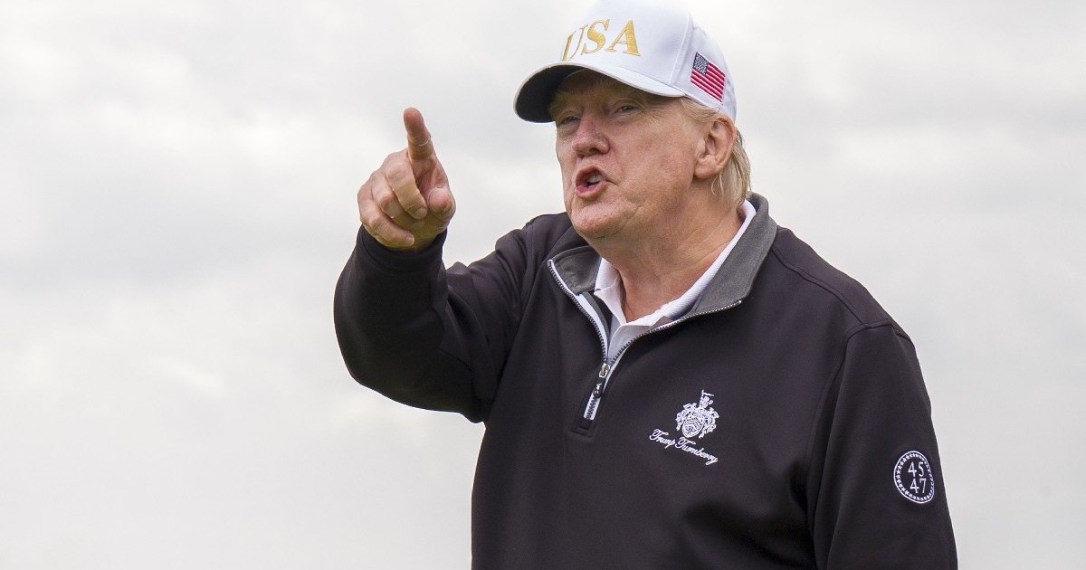 Donald Trump, îmbrăcat în hanorac negru și cu șapcă albă, pe care scrie USA, arată cu degetul - în timpul inaugurării oficiale a New Course, al doilea teren de golf de campionat de la Trump International Golf Links, pe domeniul Menie Estate din Balmedie, Aberdeenshire, 29 iulie 2025